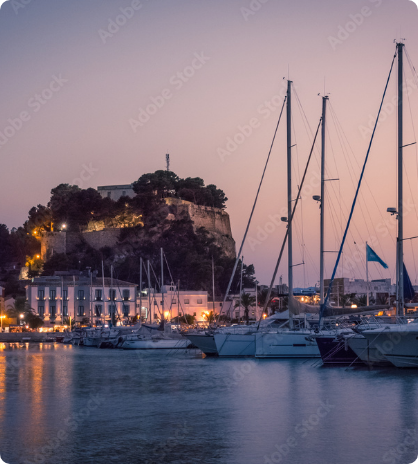 Dénia harbour at sunset with yachts and waterfront lights