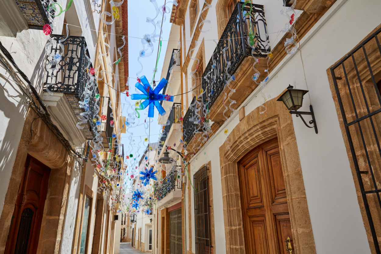 Historic street in Jávea with traditional balconies and festive decorations