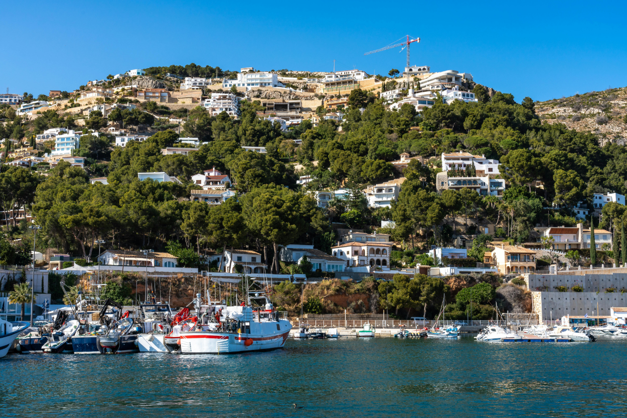 Jávea harbour with boats and hillside residences overlooking the marina
