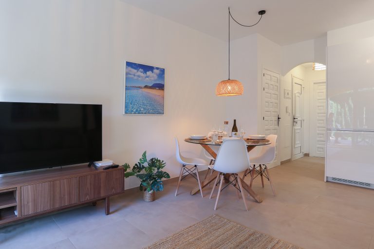 Living room with television and dining table at apartment Alquería Sol in Dénia