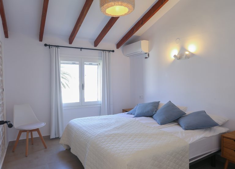 Bedroom with bedside lamps at apartment Retiro Sol B14 in Dénia