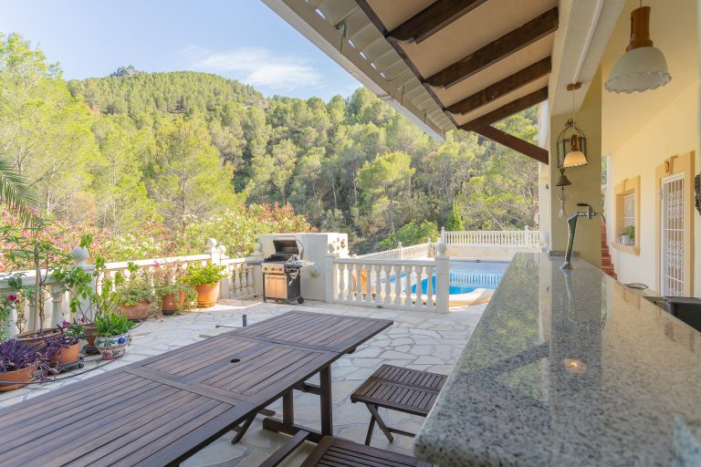 Covered terrace with outdoor dining table at Villa Casa Joni in Orba
