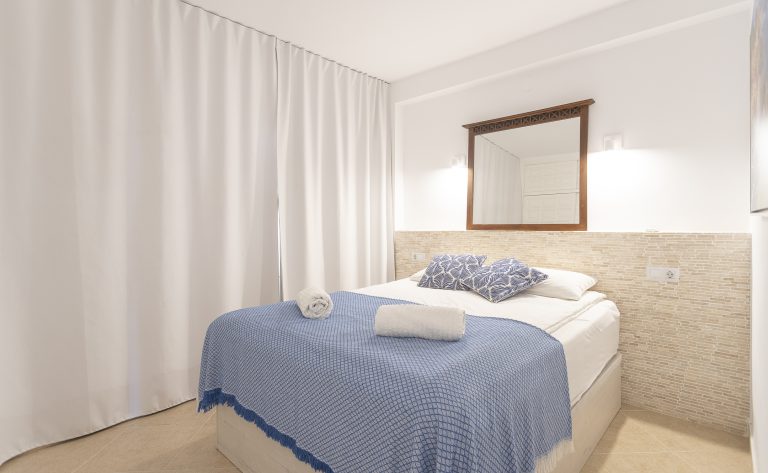 Bedroom with double bed and curtains at apartment Retiro Sol A1 in Dénia